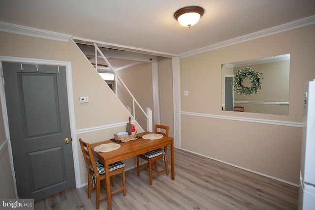 dining area with hardwood / wood-style floors and crown molding