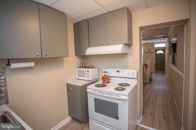 kitchen featuring a paneled ceiling, light hardwood / wood-style flooring, gray cabinets, and white appliances