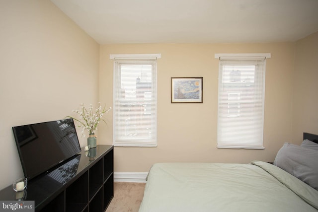 bedroom with light carpet and multiple windows