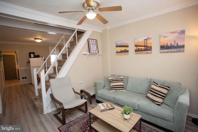 living room featuring hardwood / wood-style flooring, ceiling fan, and ornamental molding