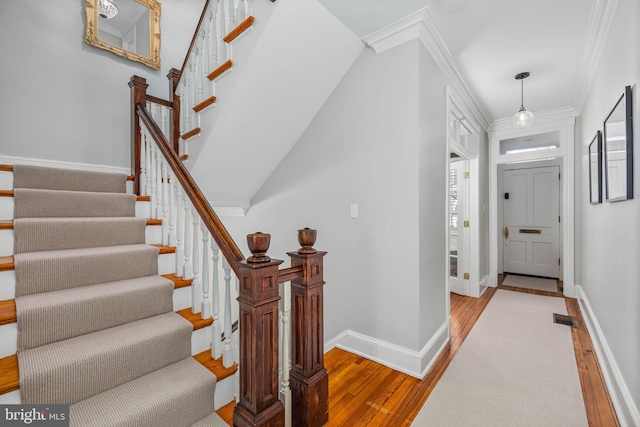 entrance foyer with light hardwood / wood-style floors and crown molding