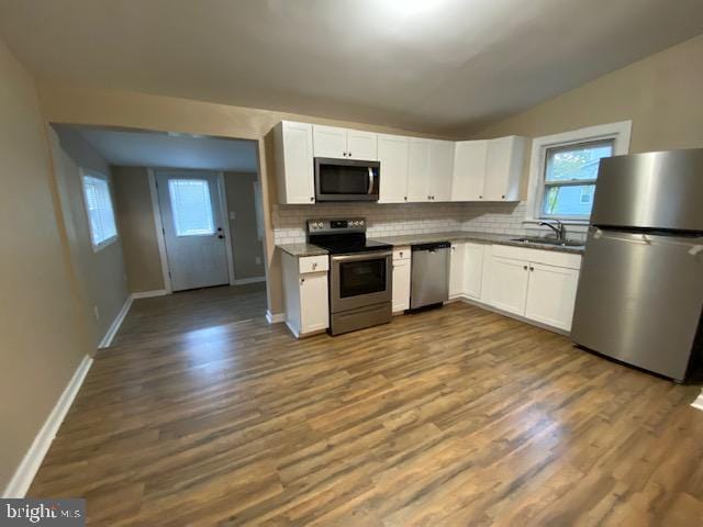 kitchen featuring stainless steel appliances, wood-type flooring, white cabinetry, and sink