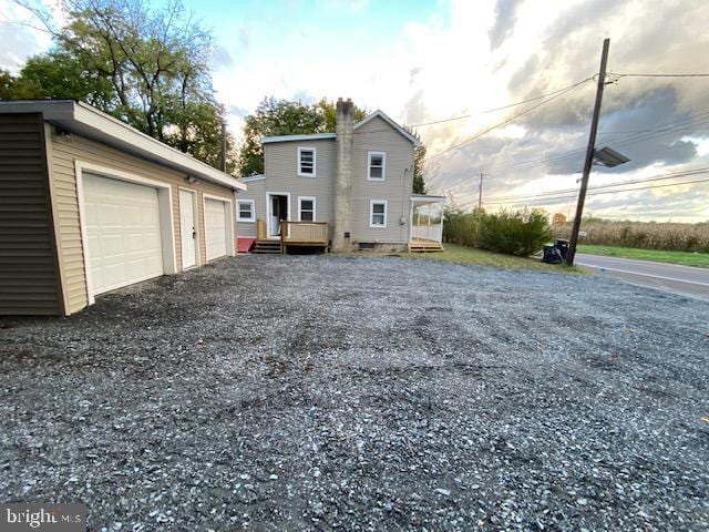 view of side of home with a garage and a wooden deck