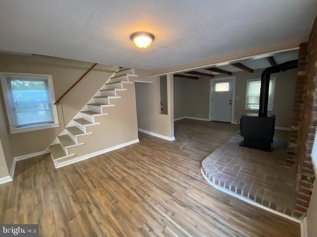 basement with a wood stove and hardwood / wood-style flooring