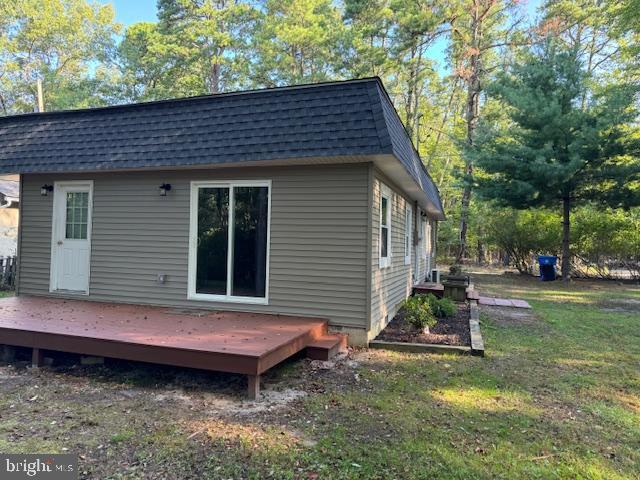 rear view of property with a yard and a deck