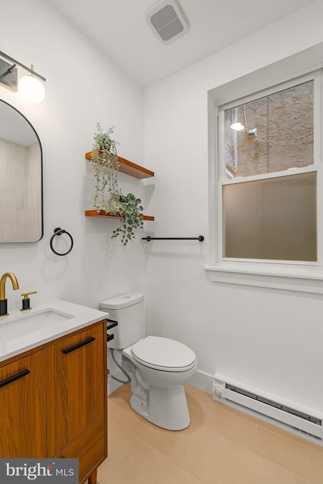 bathroom featuring toilet, vanity, tile patterned floors, and baseboard heating