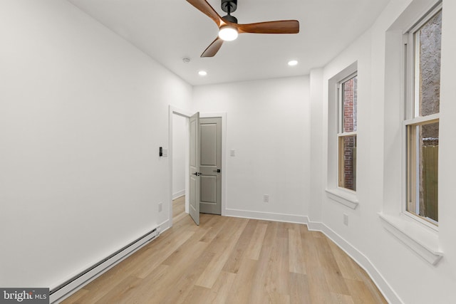 unfurnished bedroom featuring light hardwood / wood-style flooring, baseboard heating, and ceiling fan