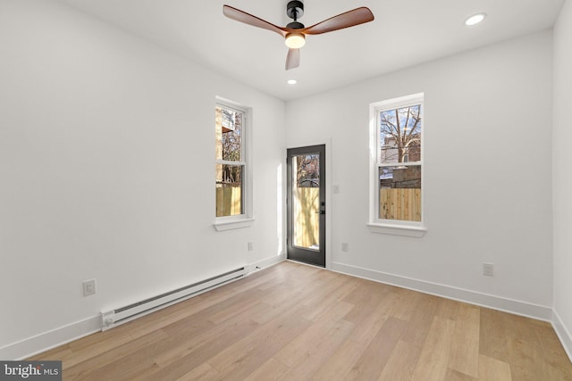 unfurnished room with ceiling fan, light hardwood / wood-style flooring, and a baseboard radiator