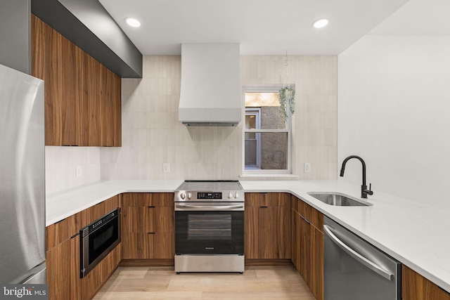 kitchen featuring tasteful backsplash, custom range hood, stainless steel appliances, sink, and light hardwood / wood-style flooring