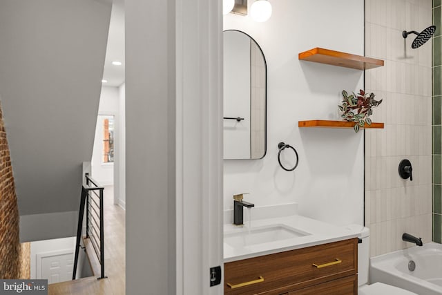 full bathroom with toilet, vanity, and tiled shower / bath