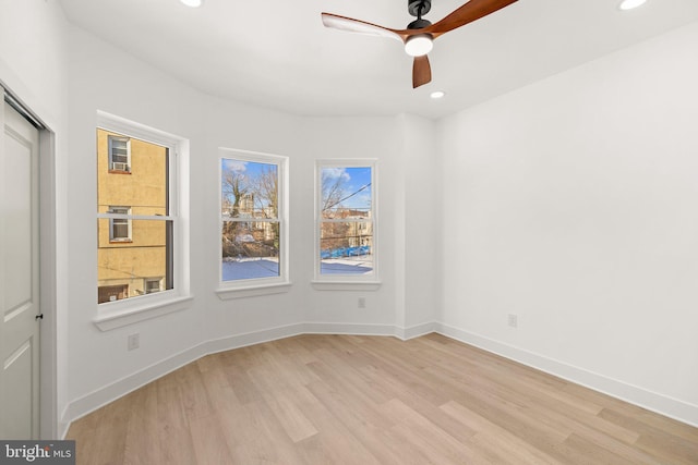 spare room with ceiling fan and light wood-type flooring