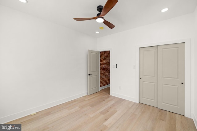 unfurnished bedroom featuring ceiling fan, a closet, and light wood-type flooring