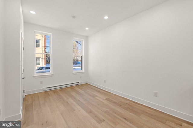 unfurnished room featuring light hardwood / wood-style floors and baseboard heating