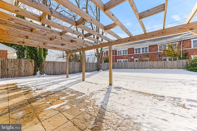 snow covered patio with a pergola