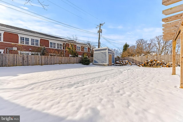 yard layered in snow with a storage unit