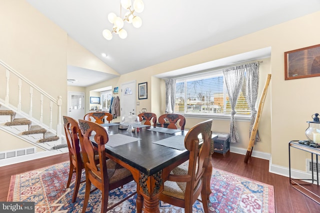 dining area featuring high vaulted ceiling, dark hardwood / wood-style floors, and an inviting chandelier