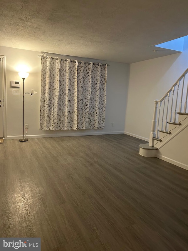 interior space with dark hardwood / wood-style flooring and a textured ceiling