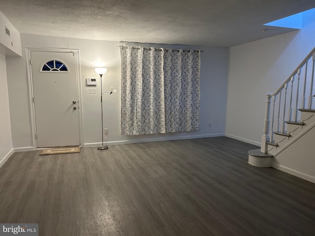 entryway with dark hardwood / wood-style flooring and a textured ceiling