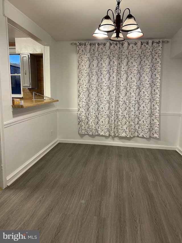 unfurnished dining area featuring dark hardwood / wood-style flooring and a notable chandelier