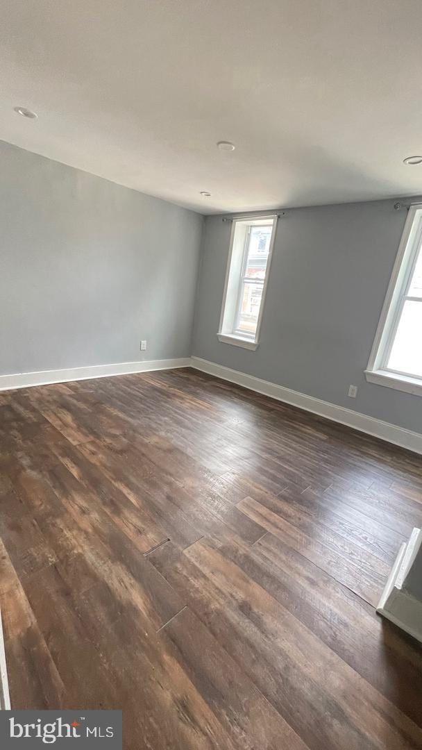 spare room with dark hardwood / wood-style flooring