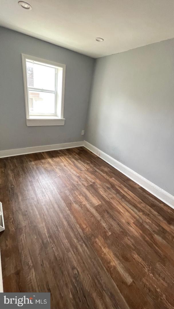 unfurnished room with dark hardwood / wood-style flooring