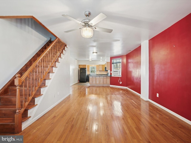 unfurnished living room featuring hardwood / wood-style flooring and ceiling fan