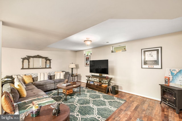 living room with a wood stove and hardwood / wood-style floors