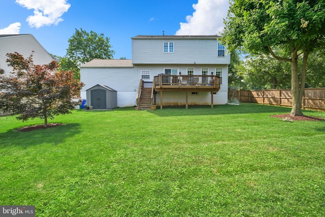 rear view of house featuring a shed, a deck, and a lawn