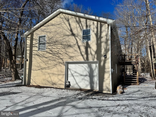 view of snow covered exterior with a garage and a deck