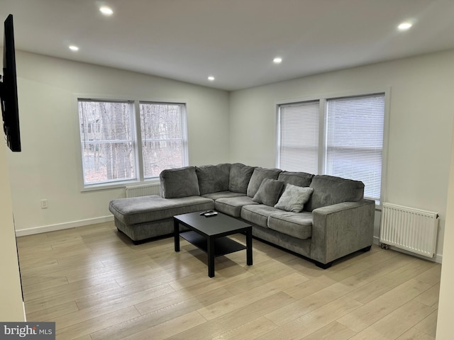 living room with radiator heating unit and light wood-type flooring