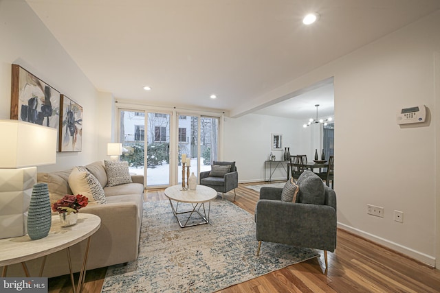 living room featuring wood-type flooring and an inviting chandelier