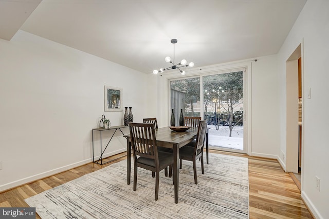 dining room featuring light wood-type flooring and a notable chandelier