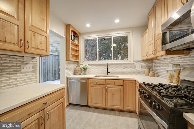 kitchen featuring decorative backsplash, sink, and appliances with stainless steel finishes