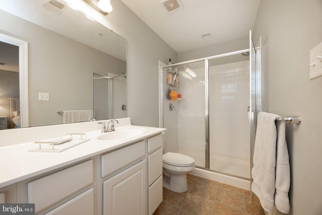 bathroom with a shower with door, vanity, and toilet