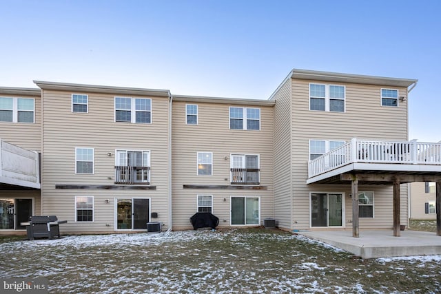 snow covered property with a patio and central AC unit