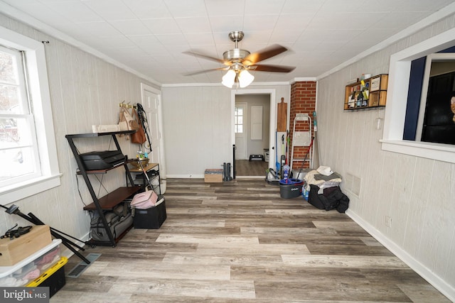 sitting room featuring ceiling fan, wood-type flooring, and ornamental molding