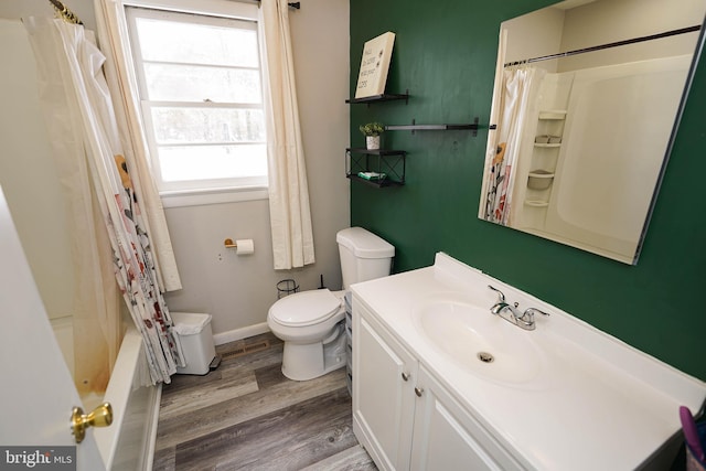 full bathroom with hardwood / wood-style floors, vanity, toilet, and shower / tub combo