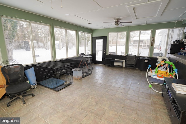 sunroom / solarium featuring ceiling fan and a healthy amount of sunlight