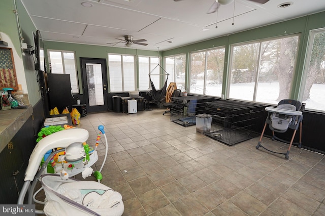 sunroom / solarium featuring ceiling fan and a healthy amount of sunlight