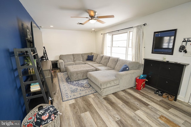 living room with wood-type flooring and ceiling fan