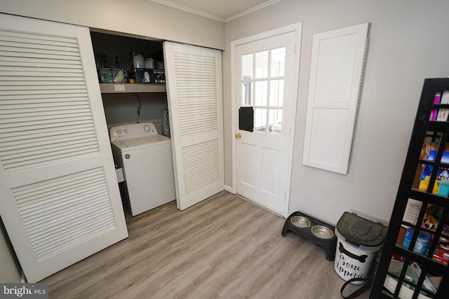 clothes washing area with washer / dryer, light wood-type flooring, and crown molding