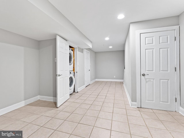 basement with stacked washer and dryer and light tile patterned floors