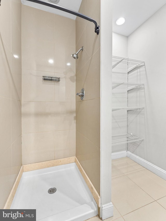 bathroom with tile patterned flooring and a tile shower