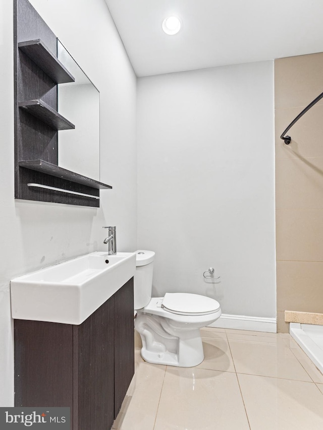 bathroom featuring tile patterned flooring, vanity, toilet, and a shower