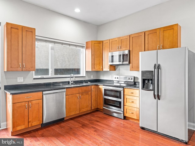 kitchen with sink, wood-type flooring, and appliances with stainless steel finishes