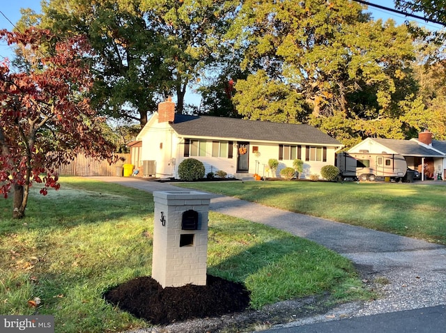 single story home featuring a front lawn and cooling unit