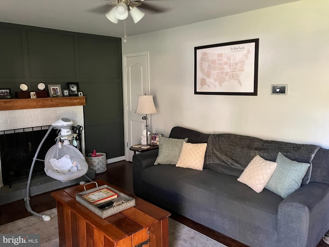 living room with ceiling fan and a brick fireplace