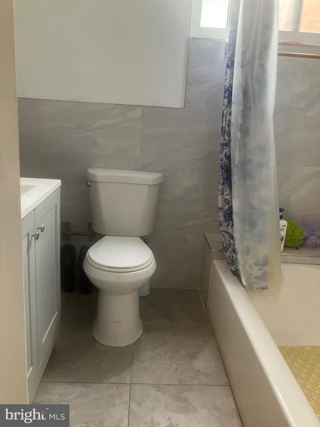 full bathroom featuring vanity, shower / bathtub combination with curtain, tile walls, tile patterned flooring, and toilet