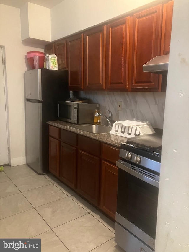 kitchen with light tile patterned flooring, backsplash, stainless steel appliances, and sink