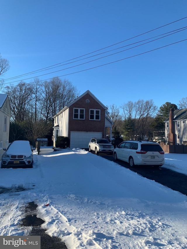 snow covered property with a garage